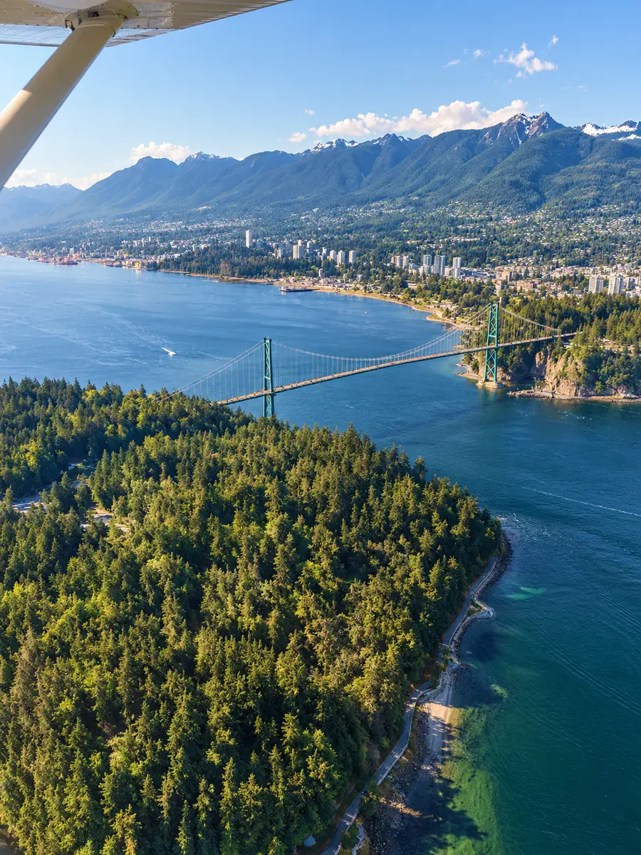 Blick aus einem Wasserflugzeug hinunter auf den Stanley Park, die Lions Gate Bridge und die North Shore
