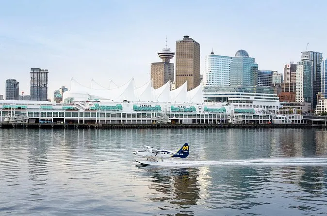 A Harbour Air floatplane taking off from the water in front of Canada Place