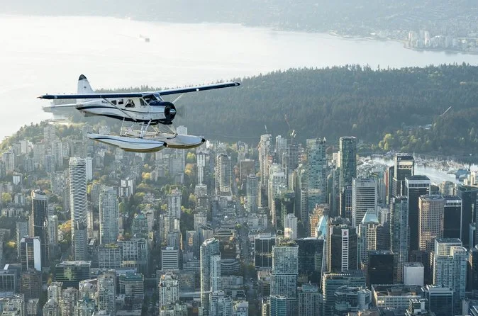 A floatplane flying over the dense towers of downtown Vancouver