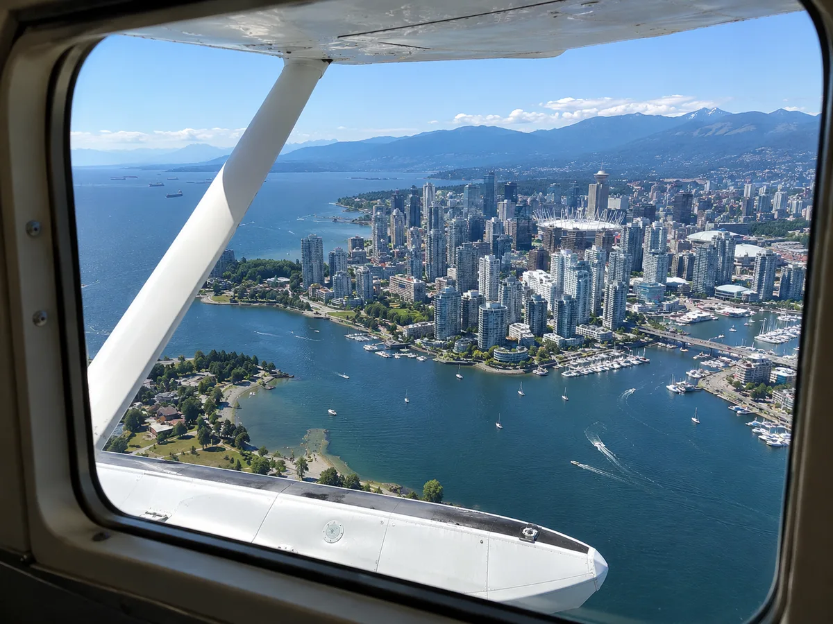 Blick durch ein Wasserflugzeug-Fenster über die Innenstadt von Vancouver, False Creek und English Bay